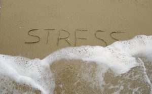photo of the words stress written in sand getting washed away by waves. Get anxiety treatment in Miramar, FL or online therapy in FL for women with Counseling Solutions of Broward