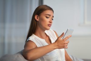 woman on her cellphone feeling sad and alone. She gets help and codependency counseling in florida with counseling solutions of broward 33023. Co-dependency recovery in Florida is possible in online therapy with telehealth.