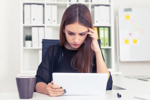 Woman looking at her laptop under stress and anxiety due to her problem with perfectionism. You can start therapy for perfectionism in Miramar, FL to deal with your perfectionism in Florida with perfectionism counseling and online therapy for women in Florida