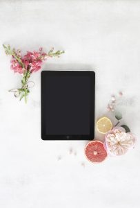 iPad with flowers and fruit around it on a white background. You can get online therapy in Florida for codependency and setting boundaries in MIramar, FL from an online therapist who specializes in relationship counseling for singles.