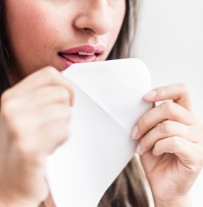Woman licks an envelope close up. Setting healthy boundaries in Florida is easier with help from a therapist for women in online therapy in Florida. Get help with divorce recovery, codependency treatment, anxiety treatment and more with healthy boundary setting and more in Miramar, FL.