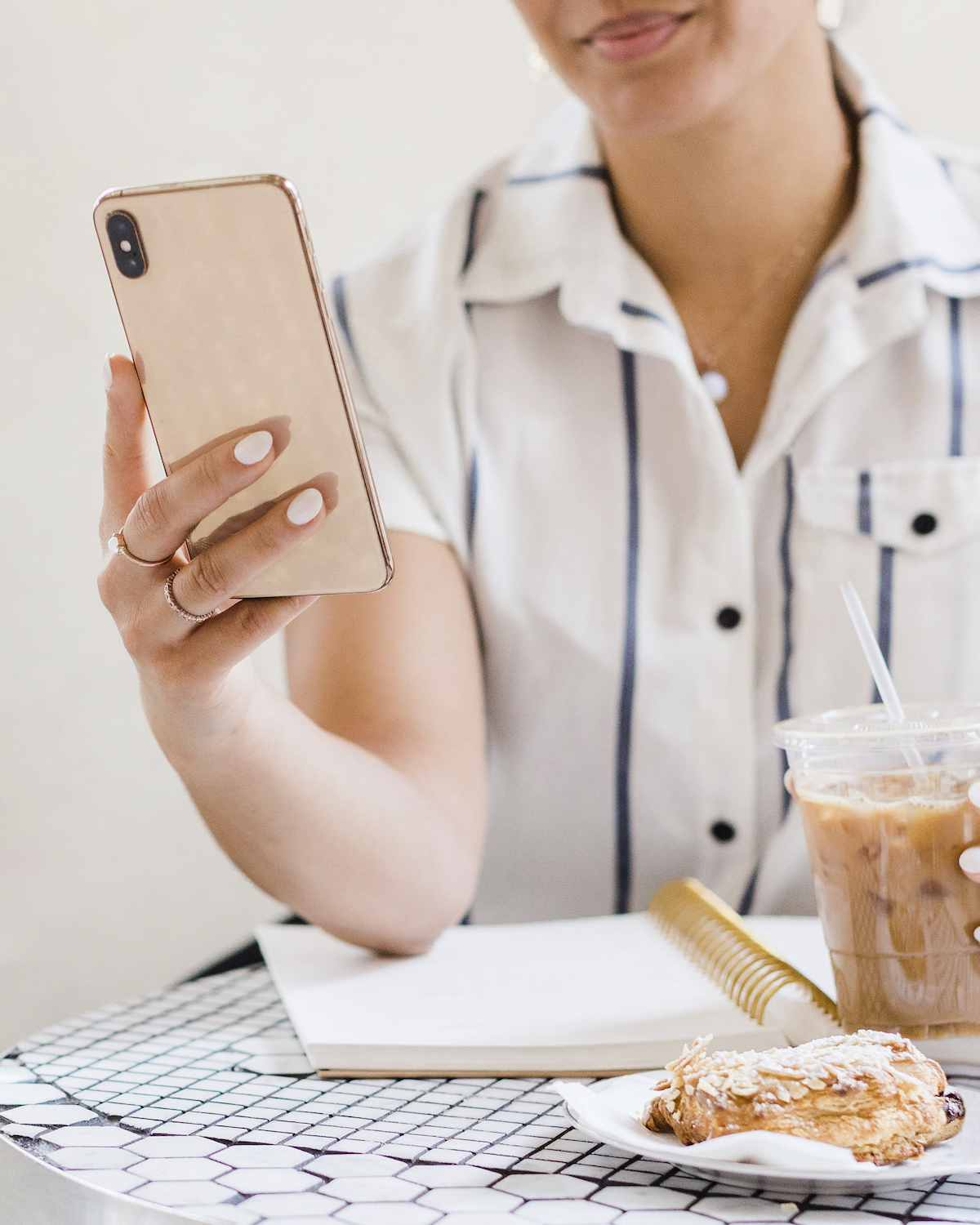 Woman at cafe working and looking at phone. Setting healthy boundaries is important for codependency treatment, perfectionism, anxiety, and more. A Florida therapist for women can help with this! Learn about healthy boundary setting here.