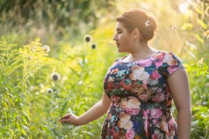 Woman in a field looking at flowers. You can get online therapy in florida with a therapist for women in Miramar, FL for codependency treatment, healthy boundaries and more.